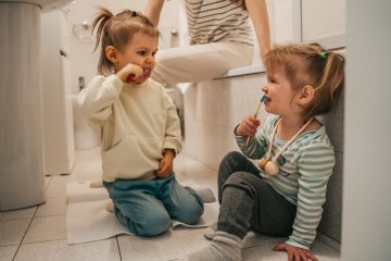 dzieci myją zęby na podłodze