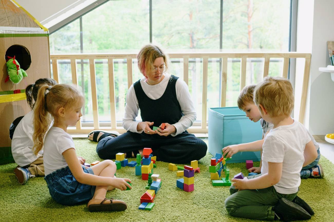 Nauczycielka bawi się z dziećmi w przedszkolu.