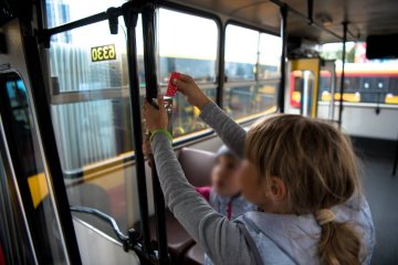 Dzieci kasują bilet w autobusie miejskim.