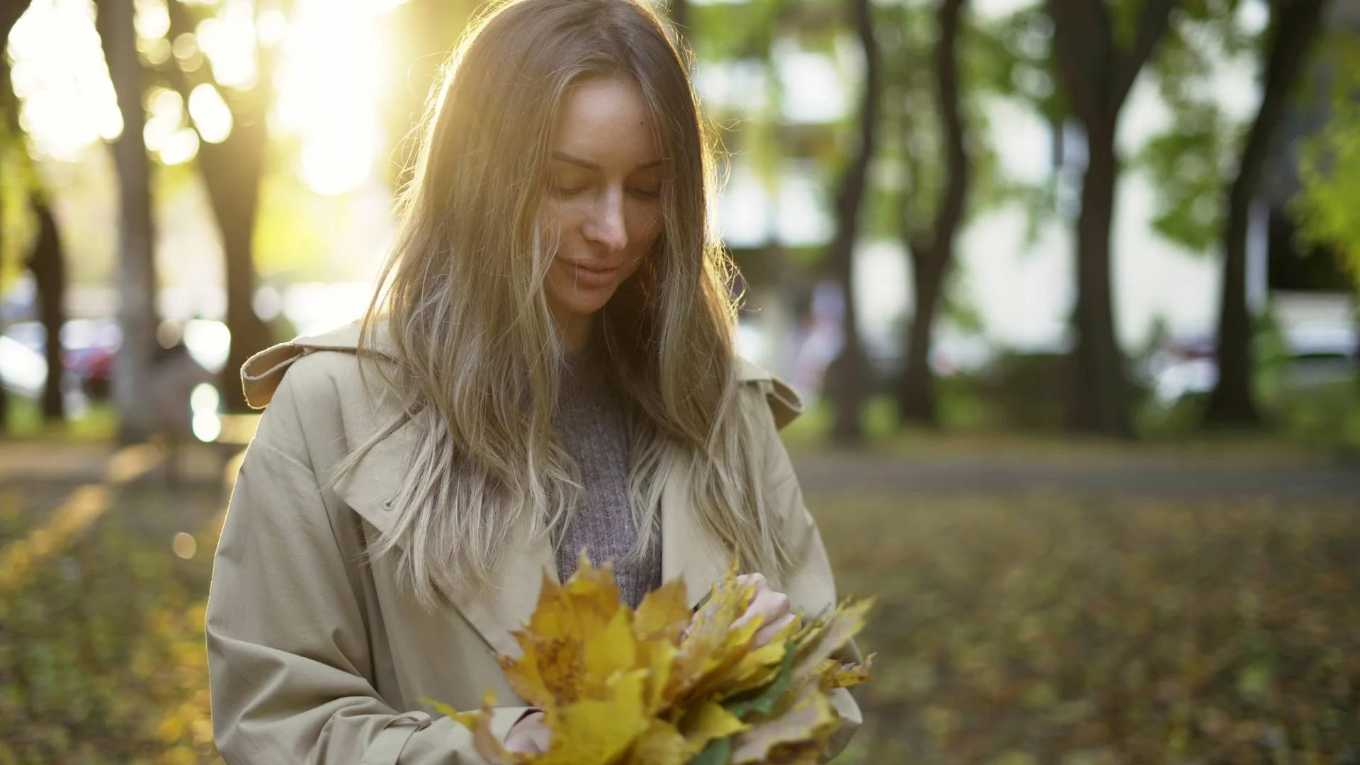 mama na spacerze w parku zbiera kolorowe liście