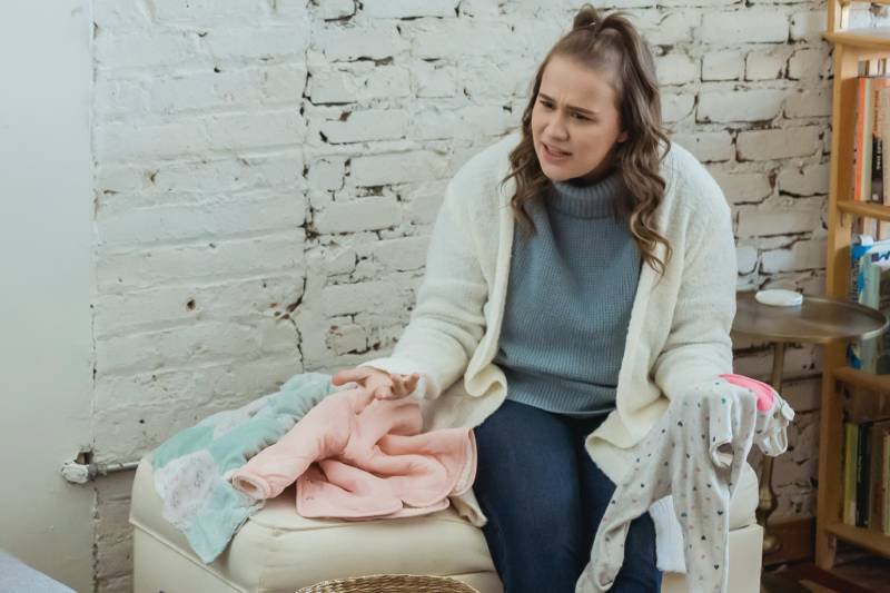 Kobieta krzyczy na męża, zbierając pranie