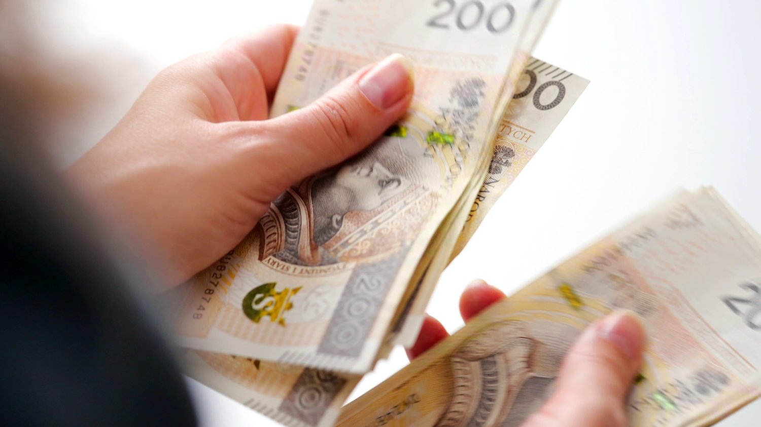 Jak skutecznie oszczędzać pieniądze? Kobieta przelicza pieniądze