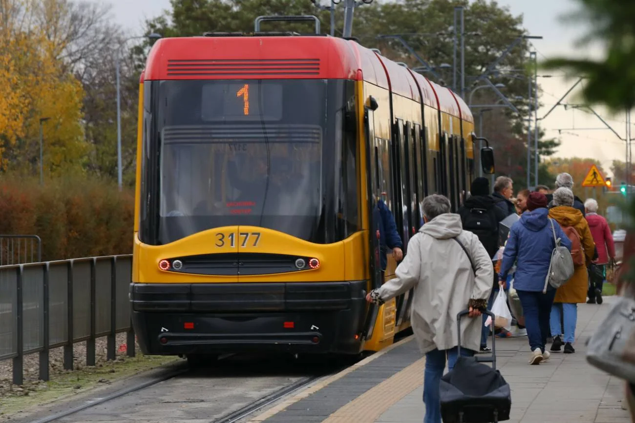 Ludzie wsiadają do warszawskiego tramwaju na przystanku.
