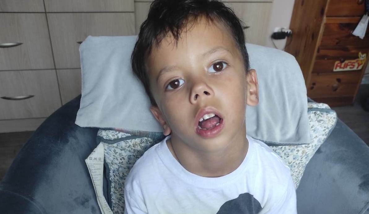 Chłopiec na wózku, uchylone usteczka, otwarte oczy.