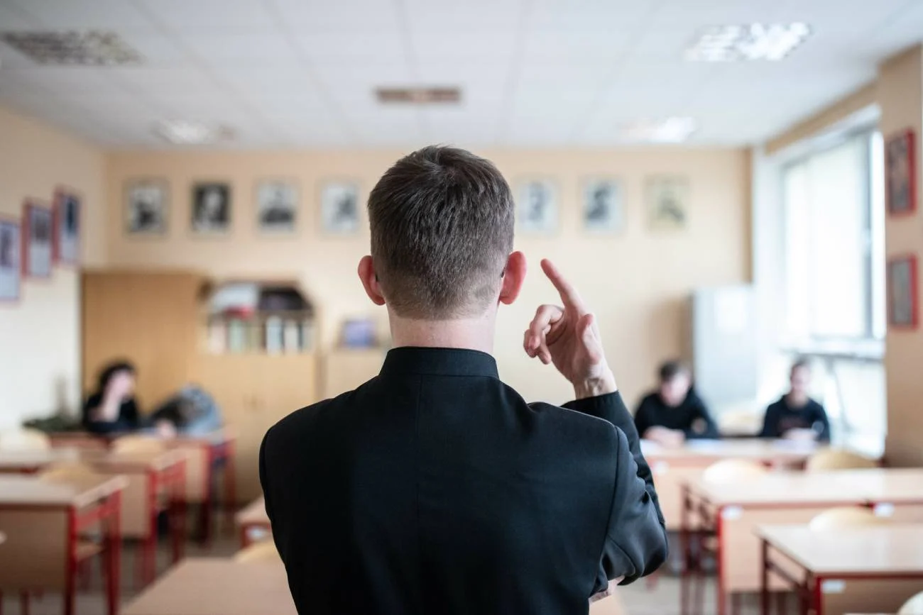 Ksiądz w klasie podczas lekcji religii.
