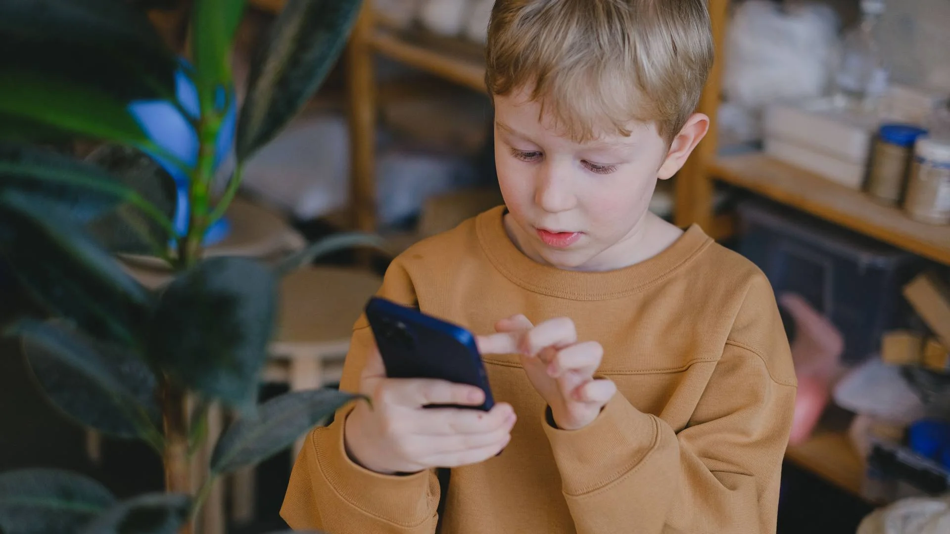chłopiec scrolluje ekran smartfona chłopiec scrolluje ekran smartfona