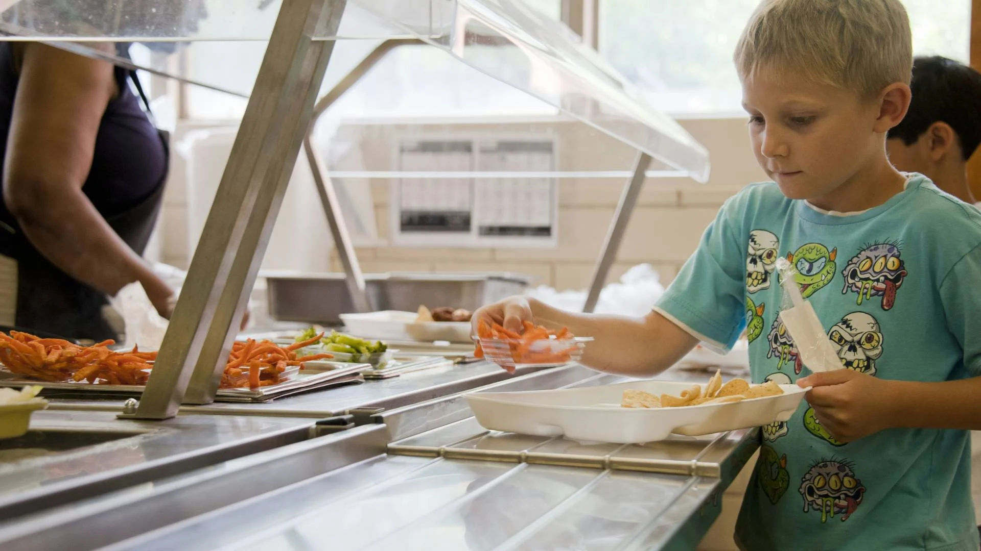 chłopiec z obiadem na szkolnej stołówce