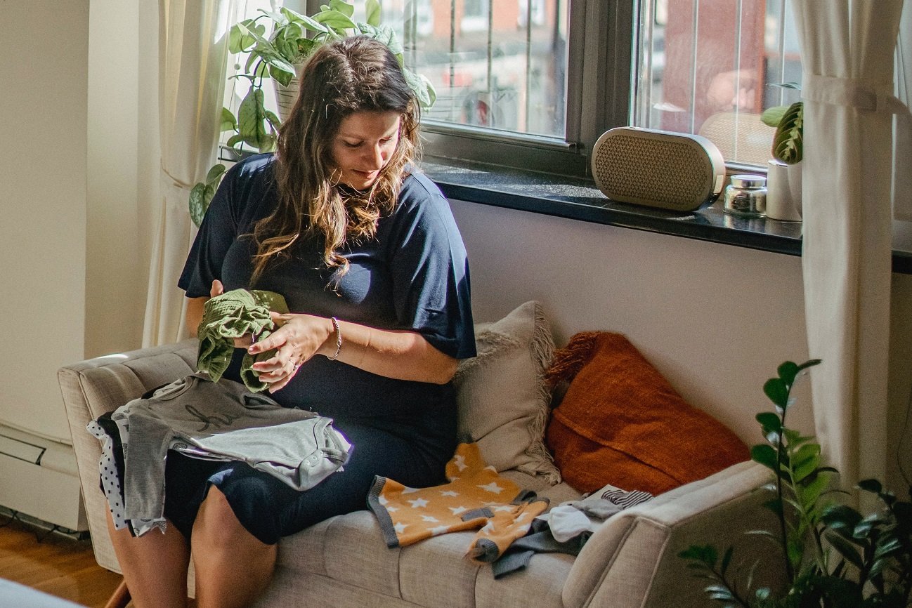 ciężarna z ubrankami dla niemowlaka