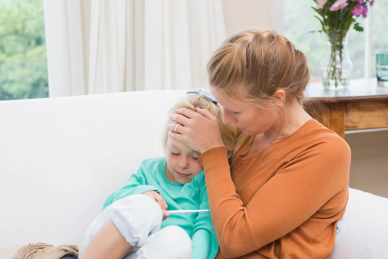 Mama z chorą córką mierzy jej temperaturę. Mama z chorą córką mierzy jej temperaturę.