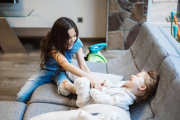 Mama i dziecko odpoczywają i bawią się na kanapie.