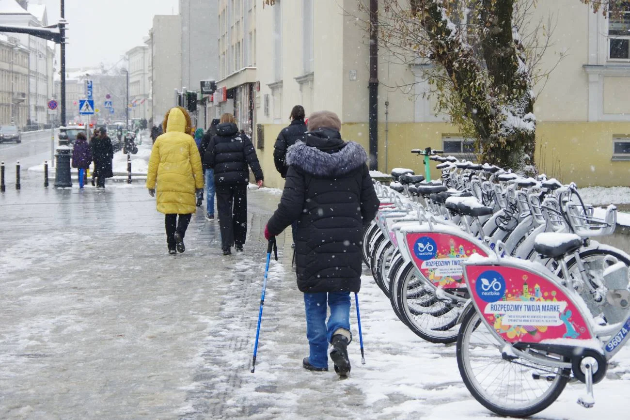 Starsze osoby idą przez miasto.