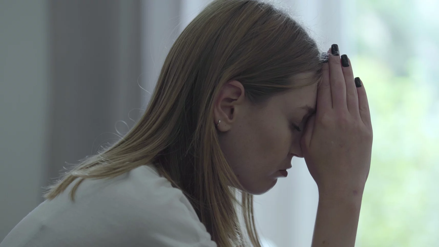 Dlaczego obrażanie się na dziecko to nie jest najlepszy pomysł? Na zdjęciu kobieta siedzi obrażona, przed twarzą trzyma złożone ręce.