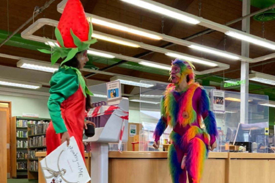 Aktorzy w bajkowych strojach, tęczowa małpa z penisem.