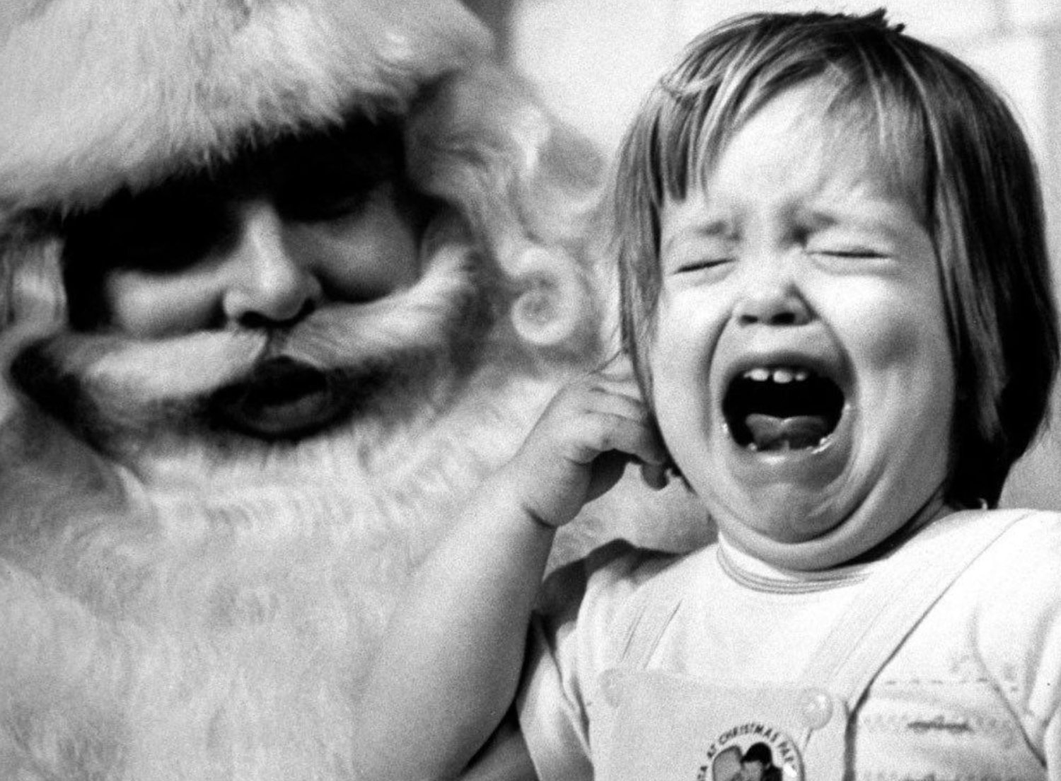 Dziewczynka płacze w obecności mężczyzny przebranego za Świętego Mikołaja.