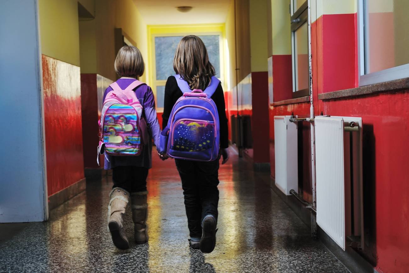 Uczennice idą szkolnym korytarzem.