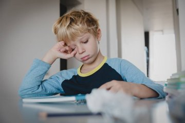 Znużony uczeń odrabia pracę domową.