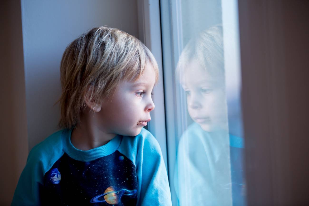Smutne dziecko wygląda przez okno. Smutne dziecko wygląda przez okno.