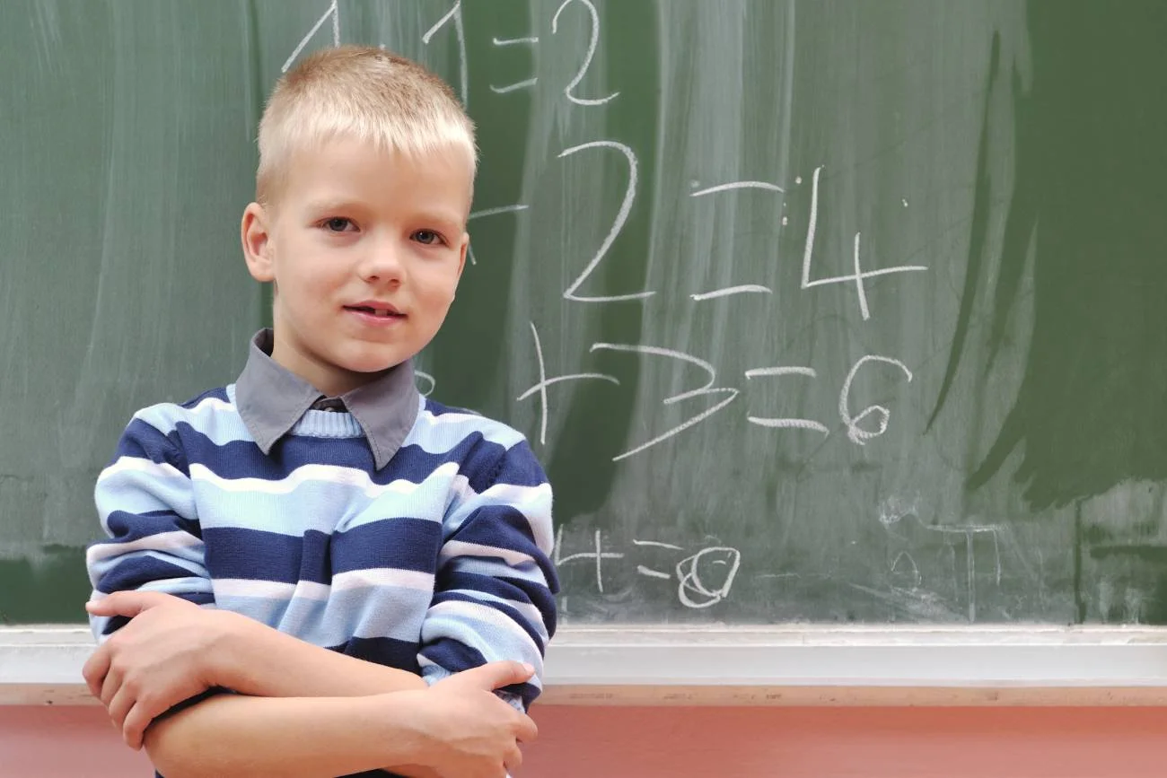 uczeń pisze na tablicy równania matematyczne
