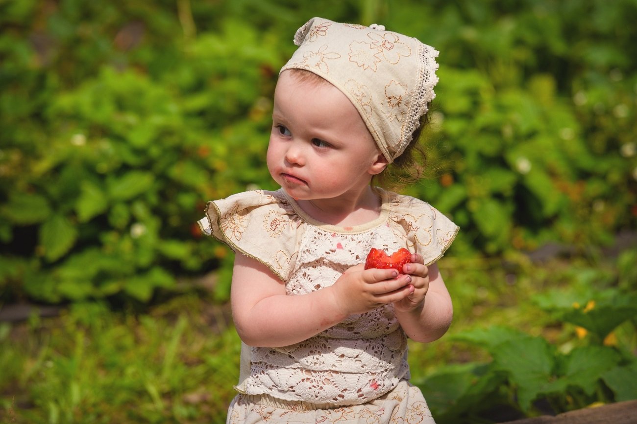 dziewczynka je truskawkę
