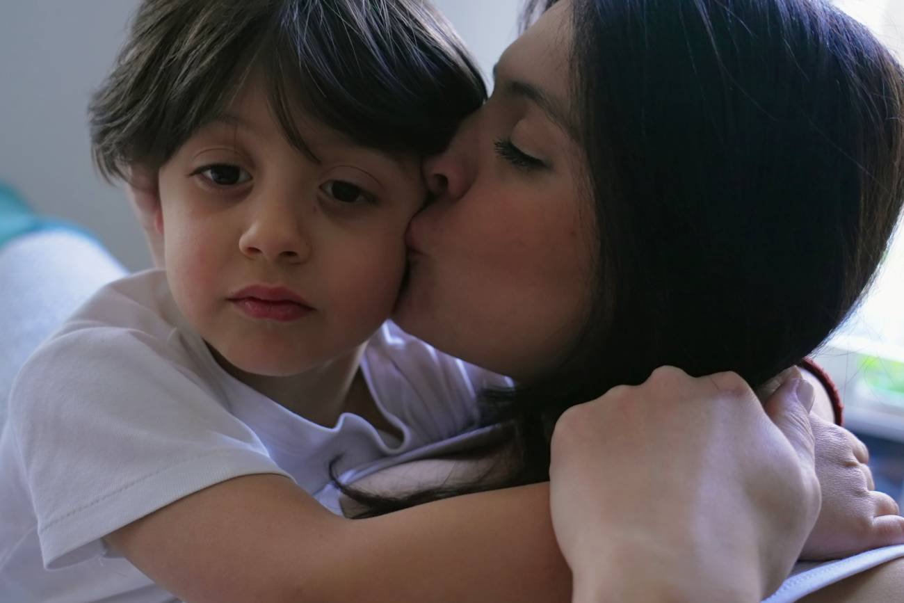 mama przytula i całuje swojego syna mama przytula i całuje swojego syna