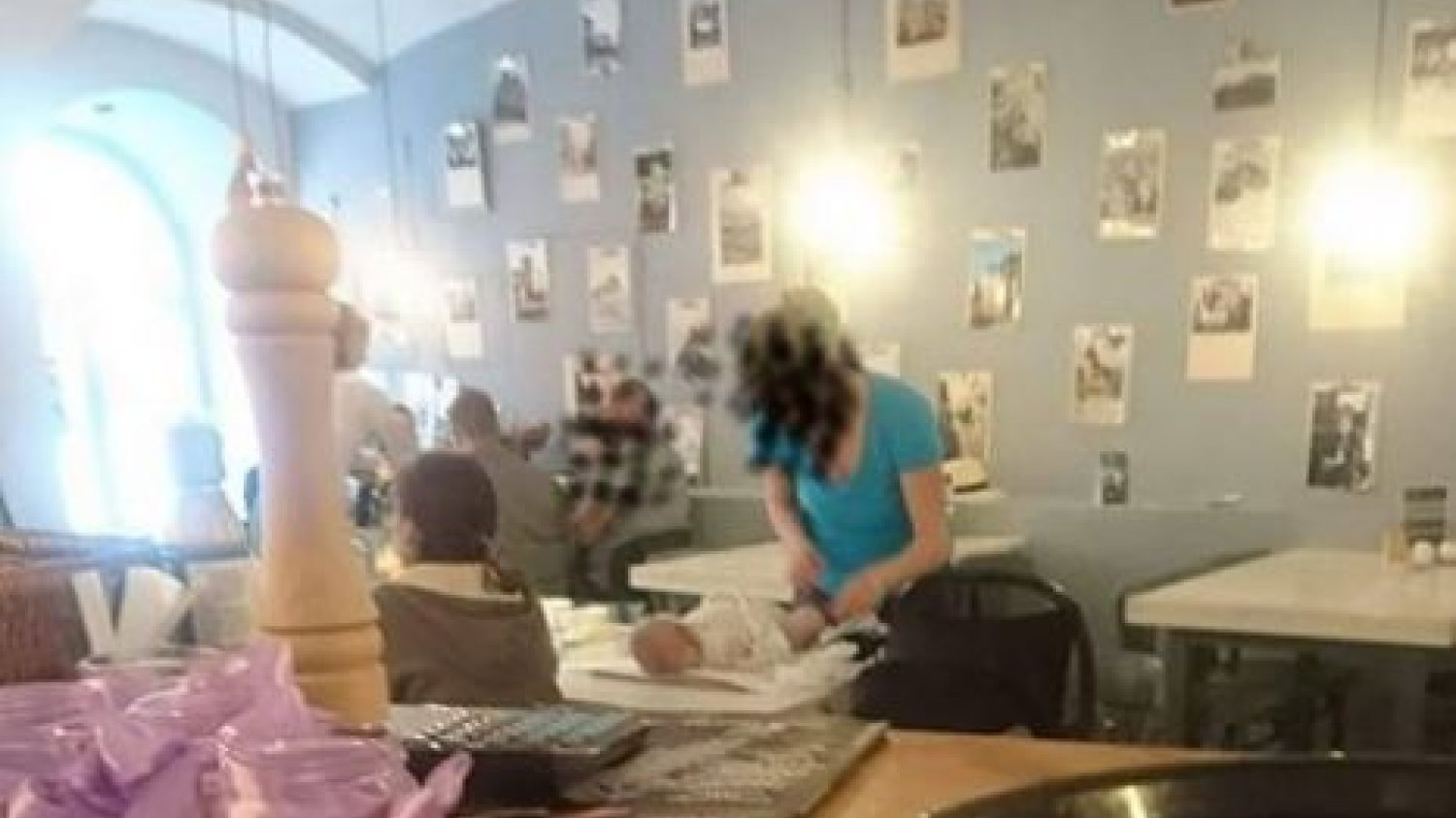 Kobieta przewinęła dziecko na stole w restauracji
