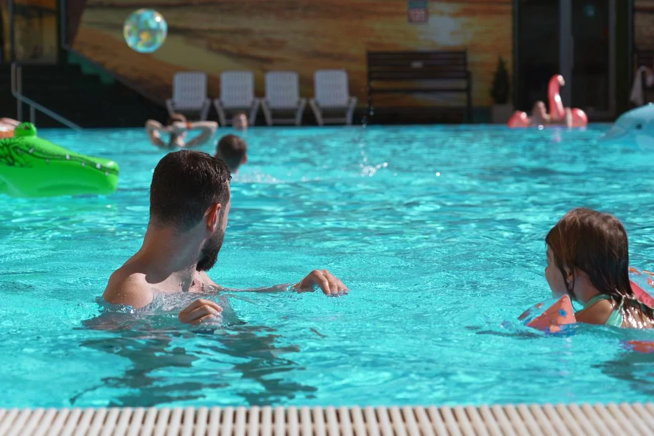 tata z dziećmi w hotelowym basenie
