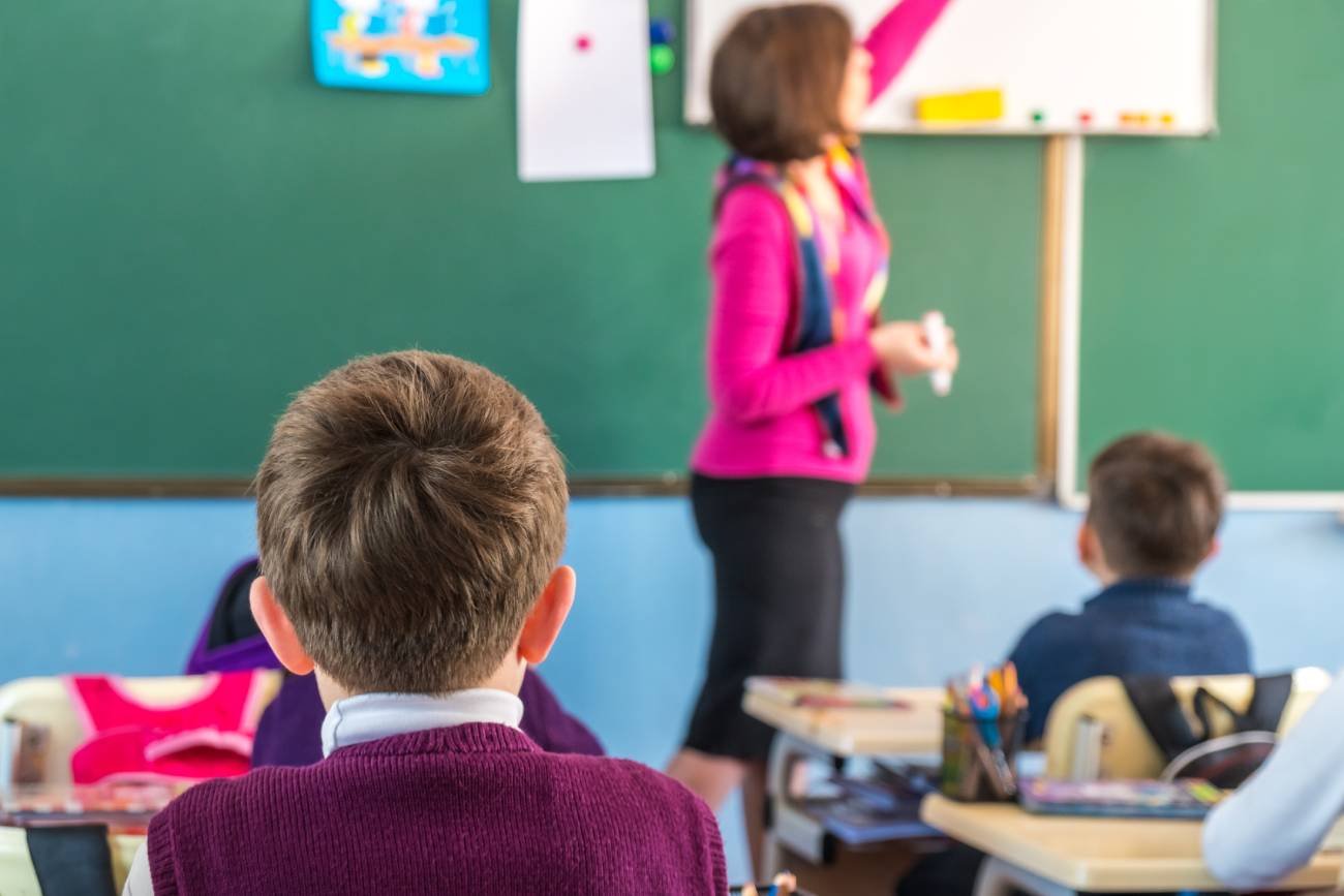 Nauczycielka prowadzi lekcję w klasie szkoły podstawowej.