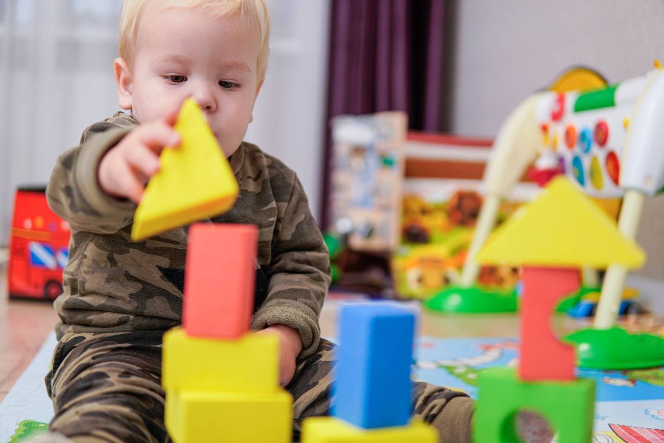 Małe dziecko bawiące się w żłobku klockami.