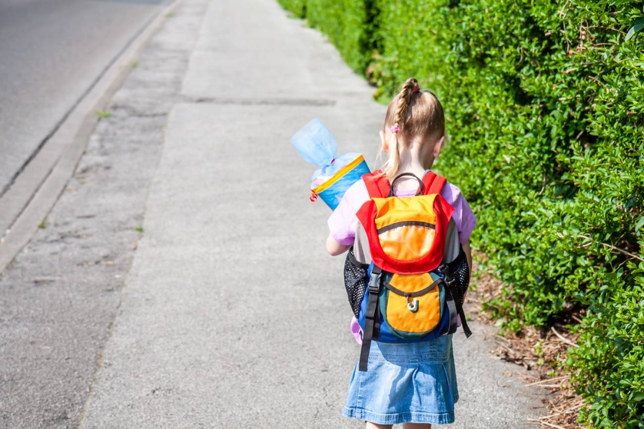 Dziecko idzie do szkoły z plecakiem.