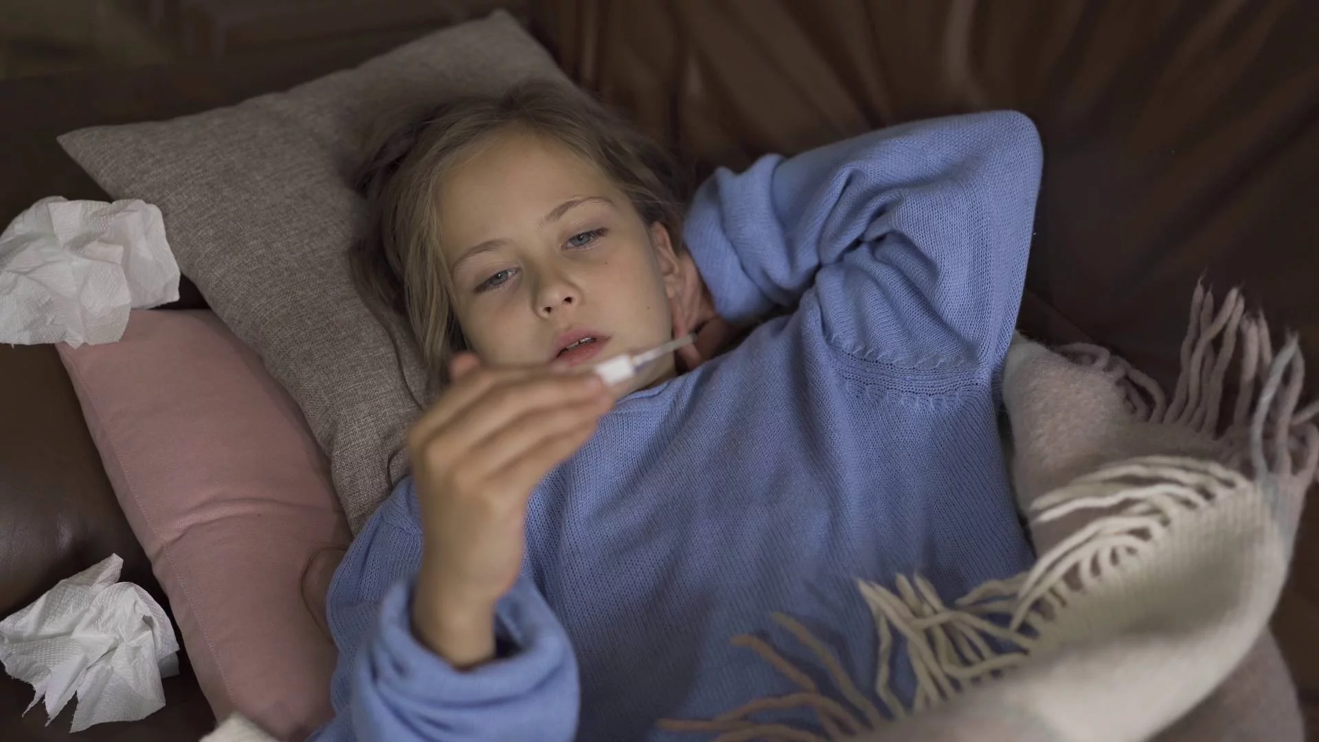 dziewczynka sprawdza temperaturę termometrem