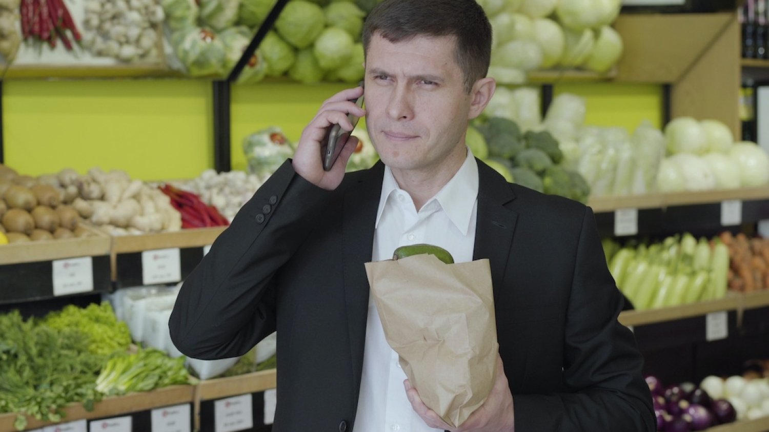Dlaczego niektórzy mężczyźni nie chcą opiekować się dzieckiem? Na zdjęciu widać mężczyznę w supermarkecie rozmawiającego przez telefon.