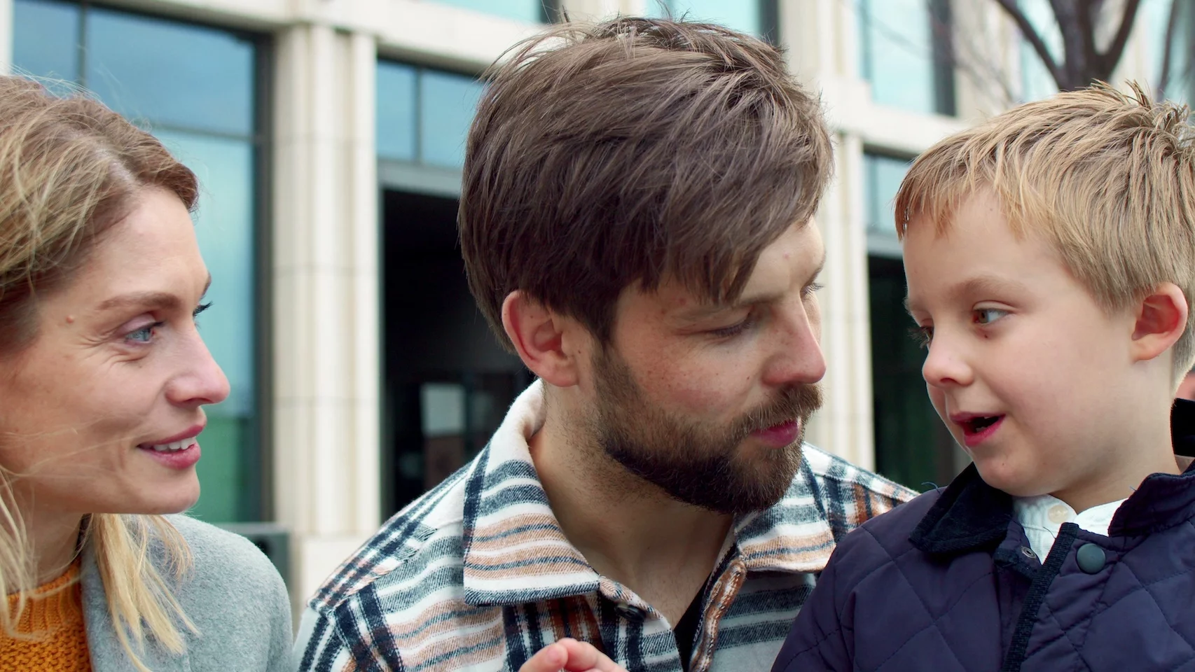 Na zdjęciu chłopiec opowiada coś rodzicom, którzy są wyraźnie zaciekawieni tą opowieścią.