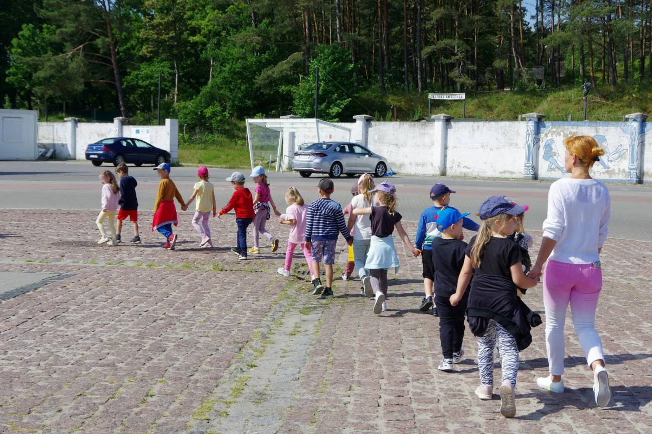 Nauczycielka z grupą przedszkolaków na wycieczce.
