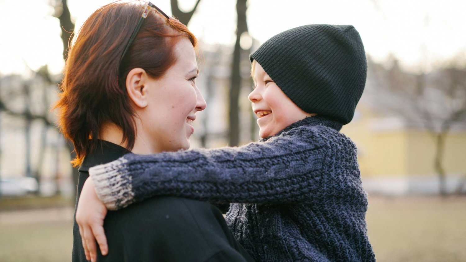 mama śmieje się z dzieckiem, które ma na rękach