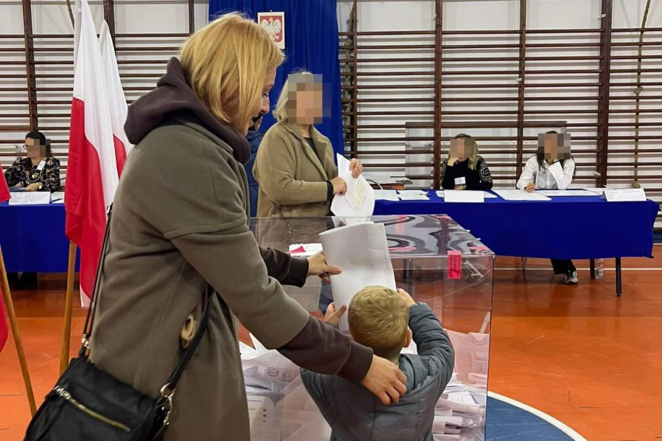 matka z dzieckiem przy urnie wyborczej