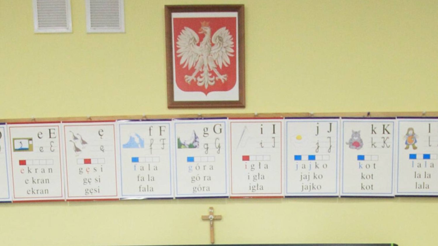 Klasa lekcyjna z krzyżem na ścianie.