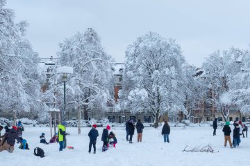 Uczniowie na przerwie zimą spędzają czas na szkolnym boisku.