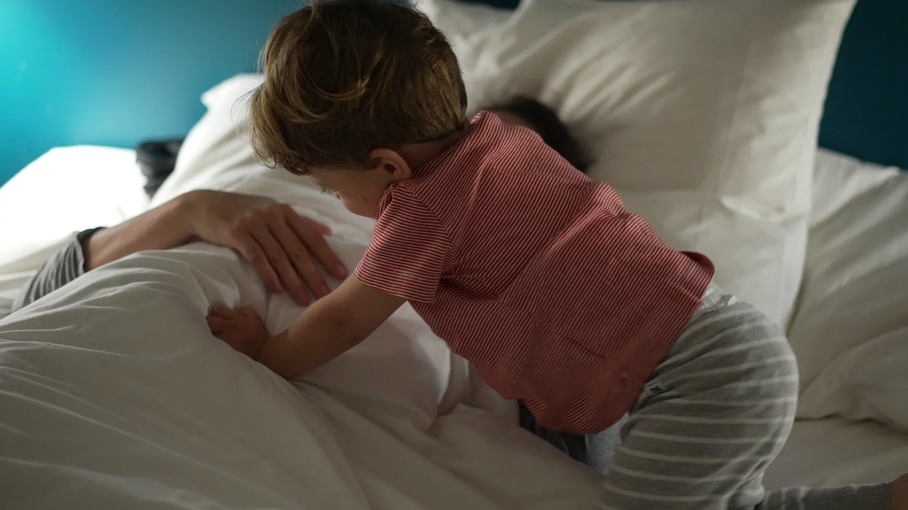 Dziecko wybudza się w nocy Na zdjęciu wybudzone dziecko przychodzi do łóżka rodziców.