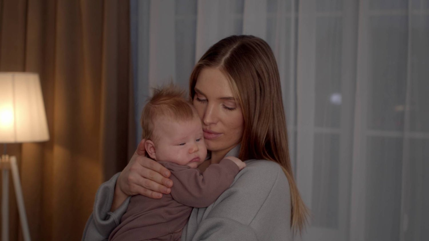 młoda mama z niemowlakiem na rękach