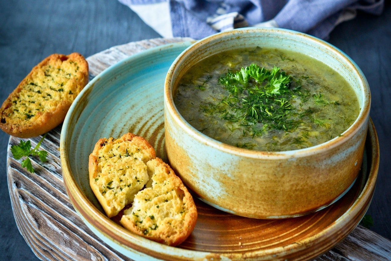 Zupa w misce, obok pieczywo.