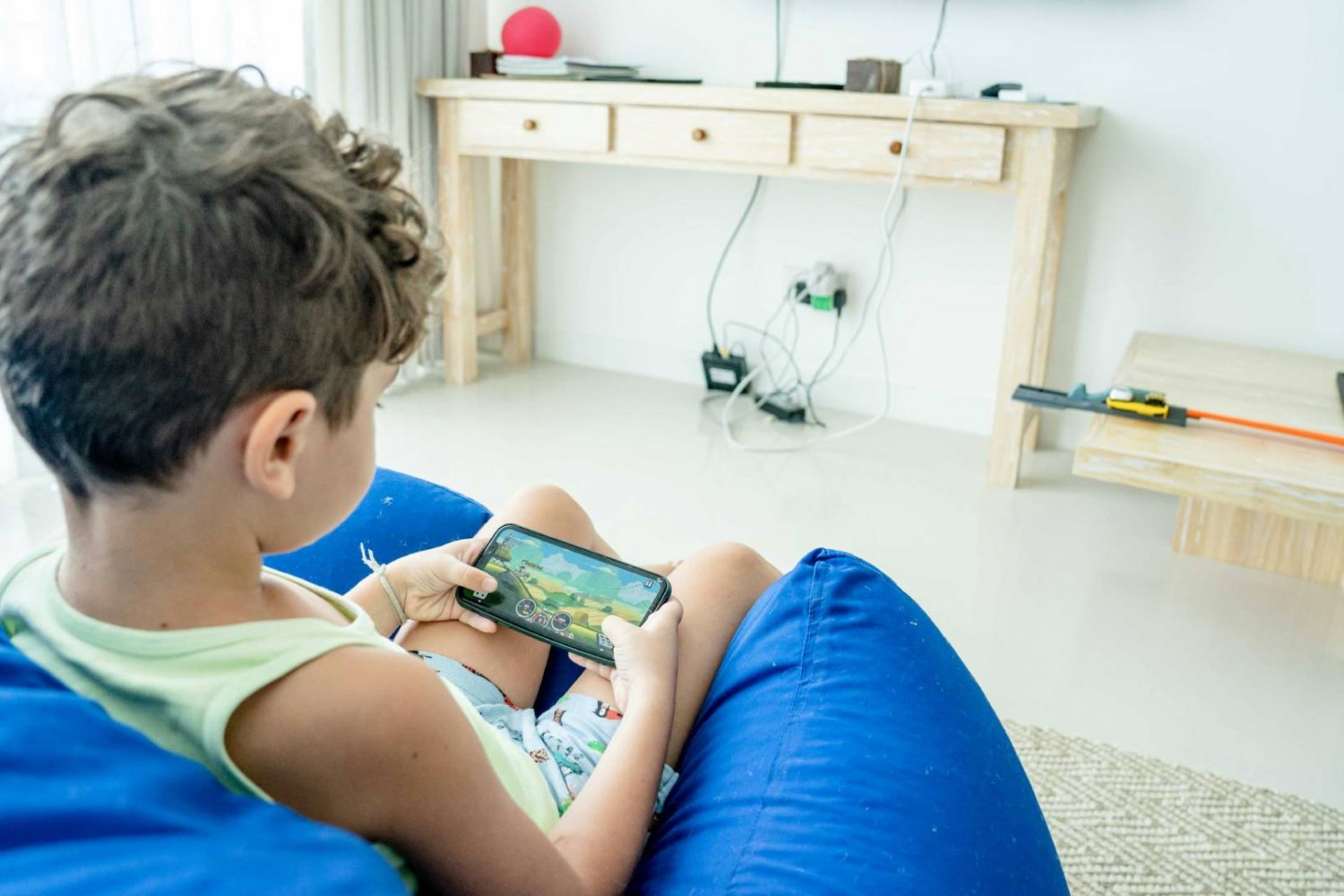 chłopiec na smartfonie ogląda film na YouTube Kids