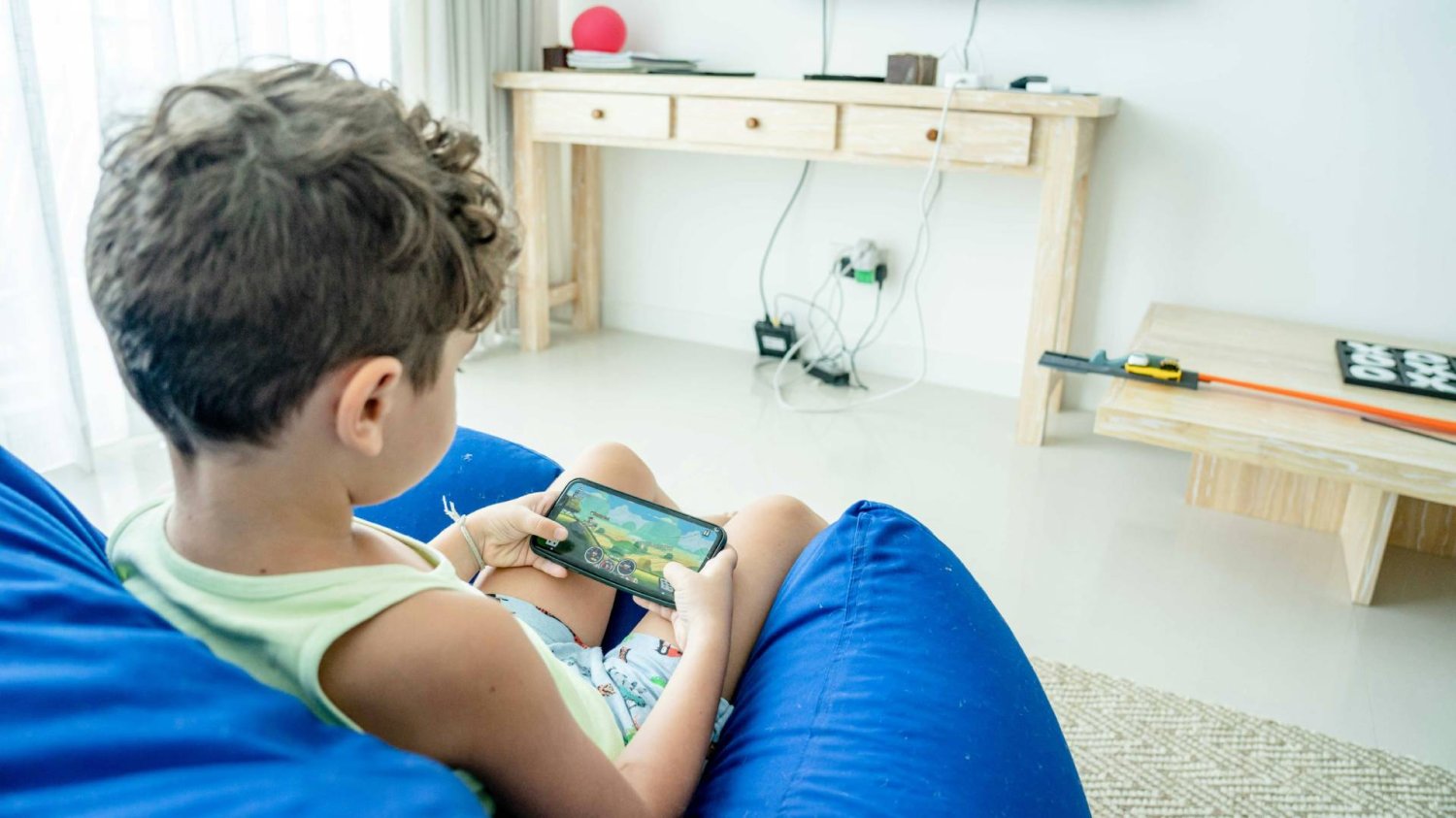 chłopiec na smartfonie ogląda film na YouTube Kids