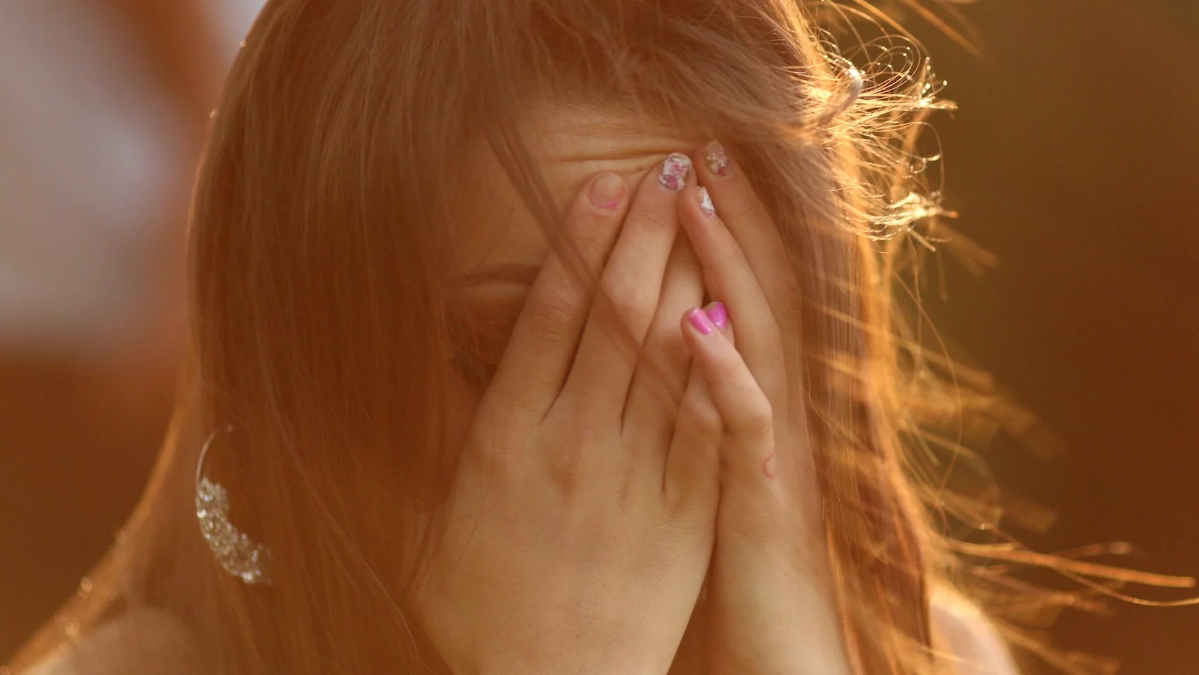 Nastolatka zasłania twarz