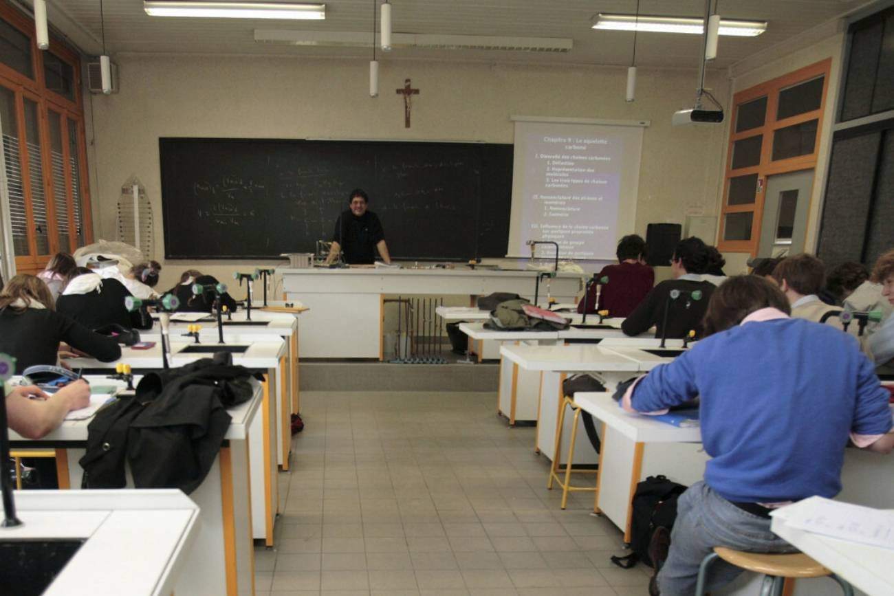 Ksiądz prowadzi lekcję religii w szkole.