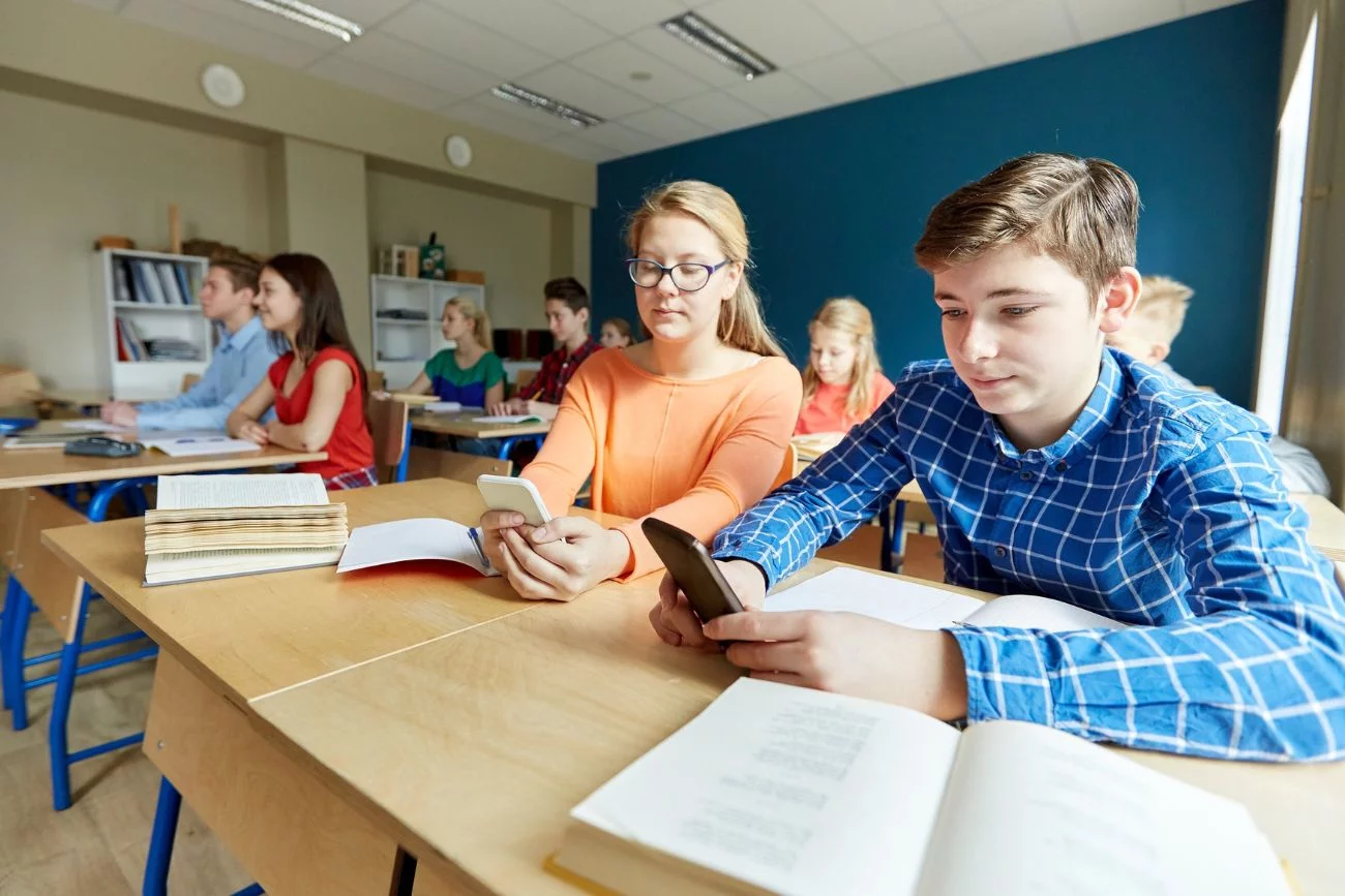 uczniowie korzystający z telefonów w trakcie lekcji