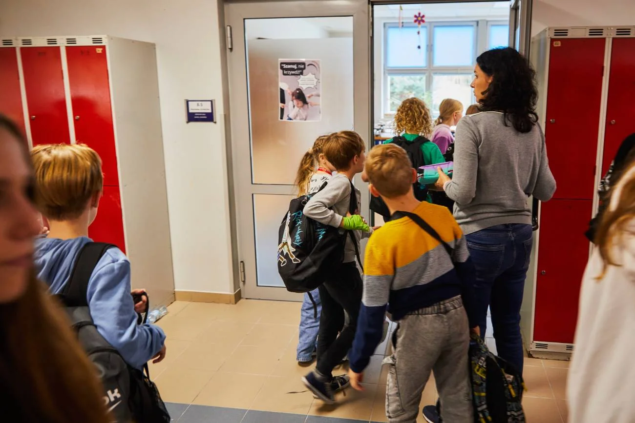 nauczycielka z klasą na korytarzu szkolnym
