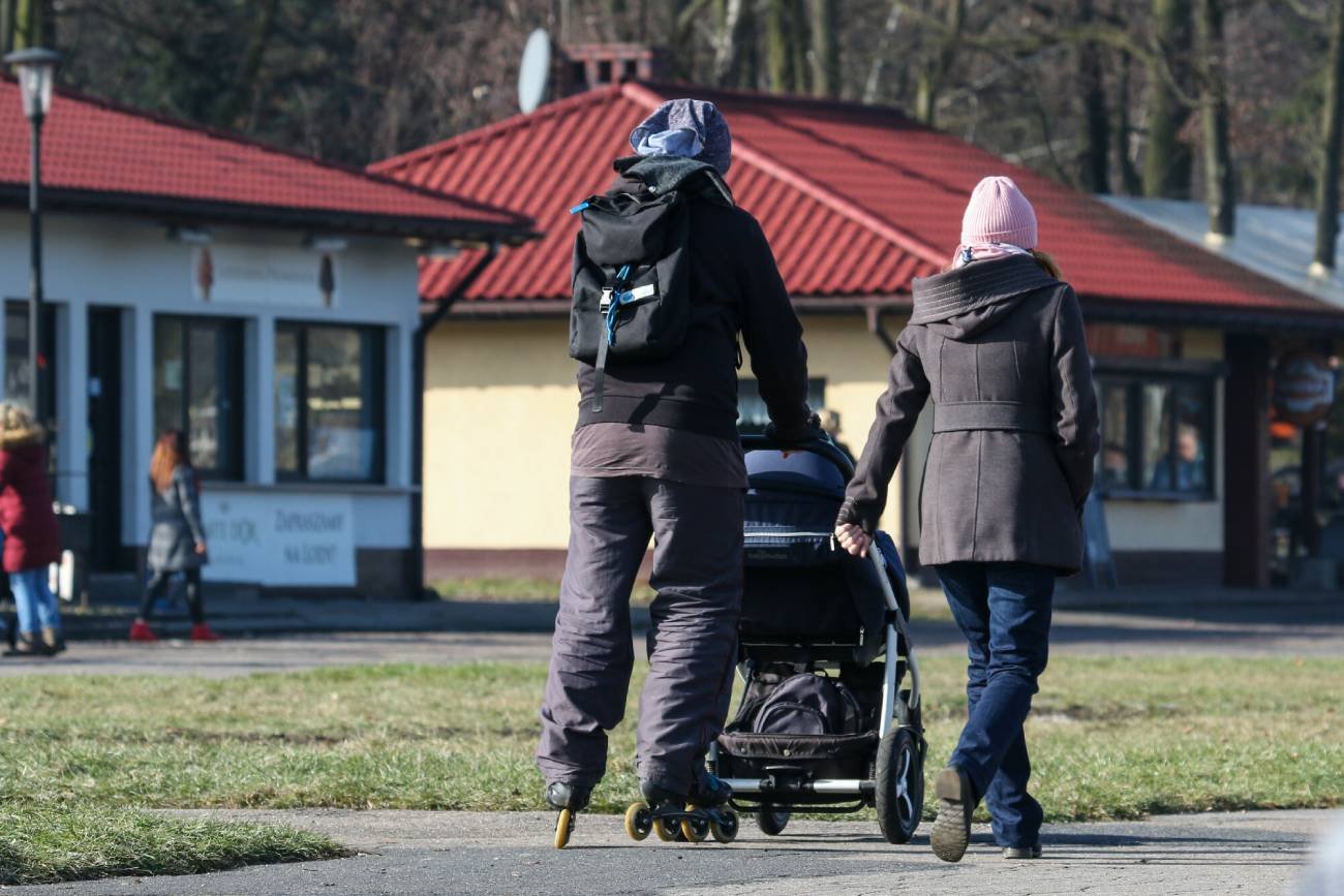 Rodzice na spacerze z dzieckiem w wózku.