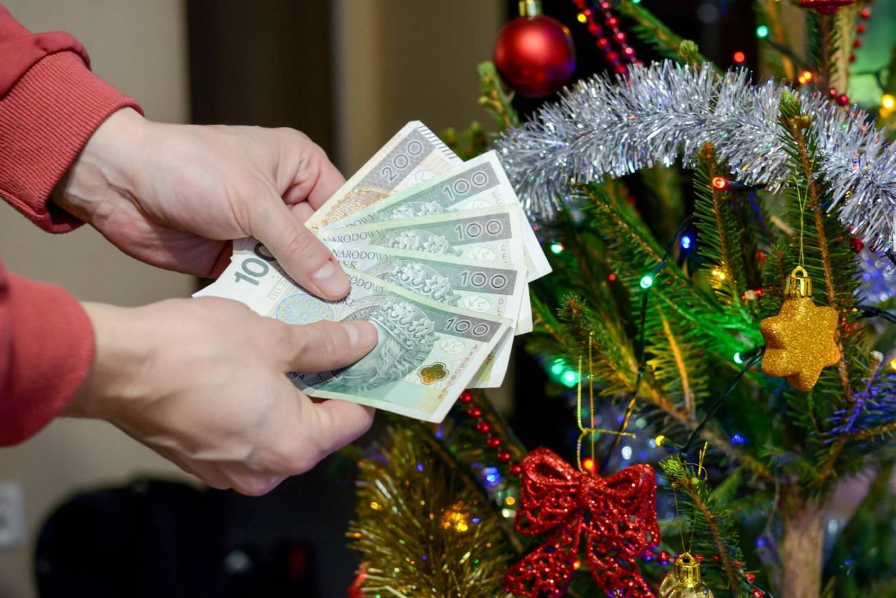 Pracownik pokazuje banknoty za karpiowe. Pracownik pokazuje banknoty za karpiowe.