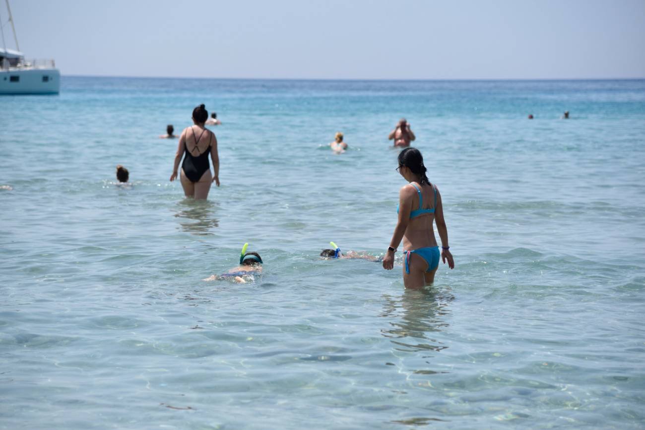 Rodzice z dziećmi na plaży w Grecji.