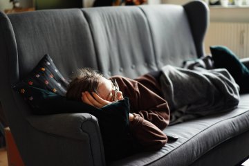 młody człowiek na kanapie w domu rodziców